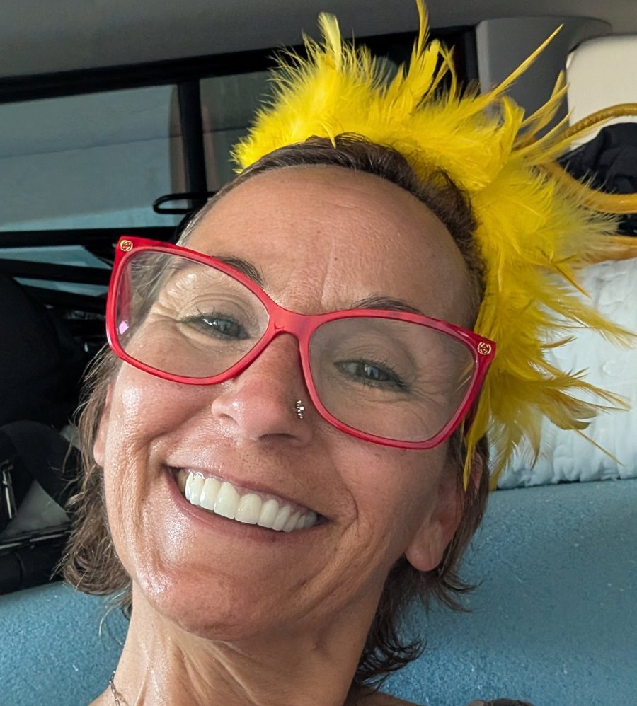 Sunshine Barcelo smiling, wearing her signature yellow feather Sunshine Crown